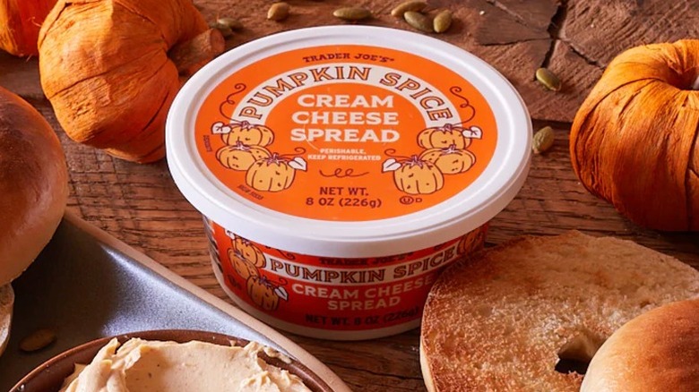 Trader Joe's Pumpkin Spice Cream Cheese Spread on a table with bagels and pumpkins