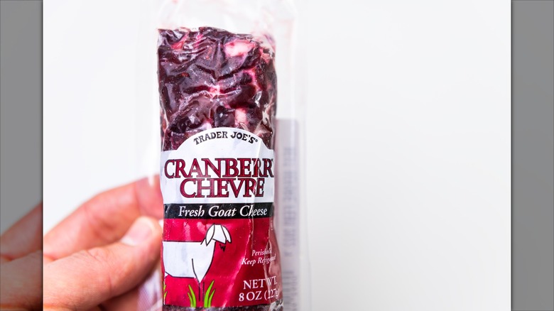 Hand holding log of Trader Joe's cranberry chevre goat cheese
