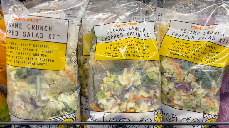 Bags of Trader Joe's Sesame Crunch chopped salad kit on store shelf