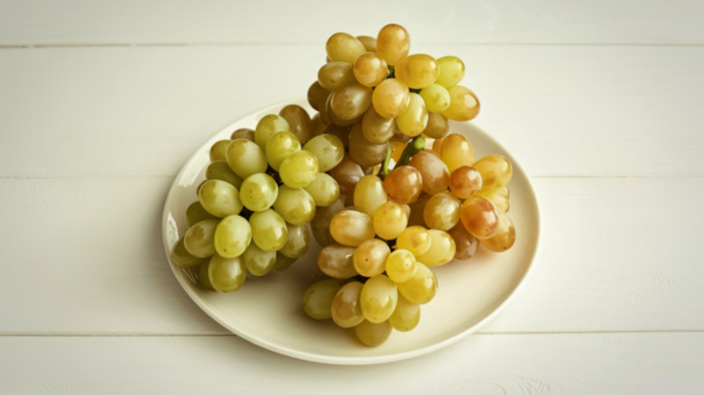 Several bunches of grapes on plate.