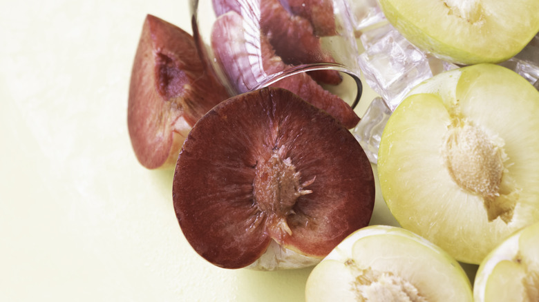 Several plumcots sliced open to show interiors.