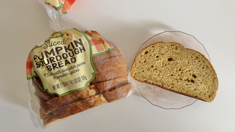 Bag of TJ pumpkin sourdough bread with one slice on plate