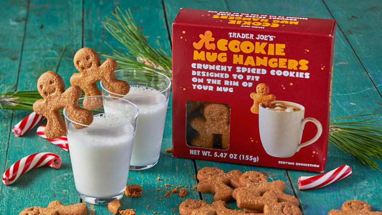 Two glasses of milk with Trader Joe's Cookie Mug Hangers next to a  box of the cookies