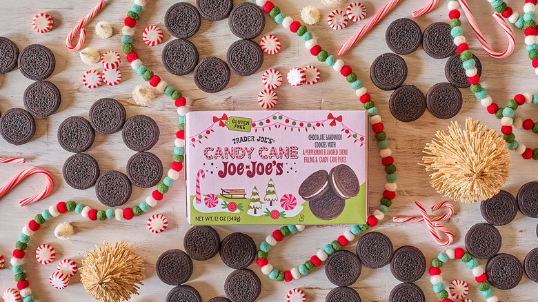 A box of Trader Joe's Gluten-Free Candy Cane Joe-Joe's surrounded by cookies and holiday decorations