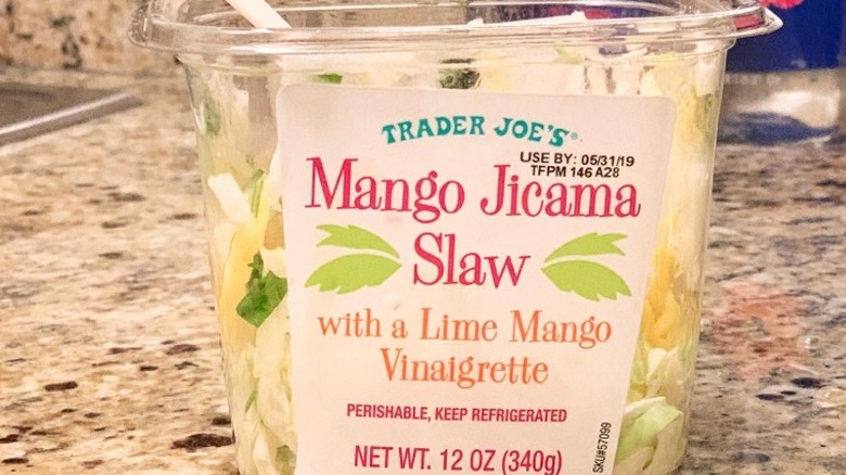 A container of Trader Joe's Mango Jicama Slaw on marble counter