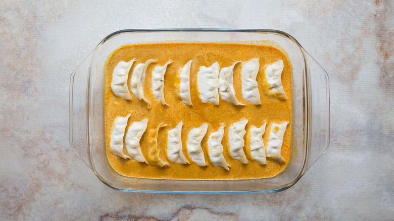 uncooked dumplings in baking pan