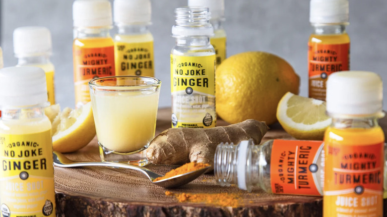 Trader Joe's organic juice shots beside a cup of juice