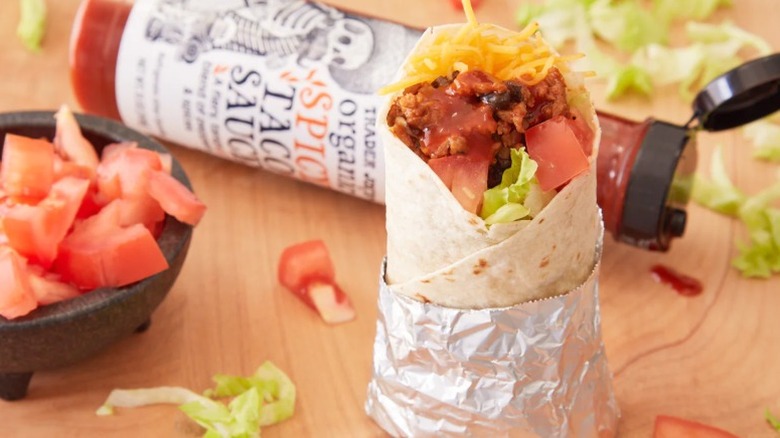 Burrito with spicy taco sauce and bottle