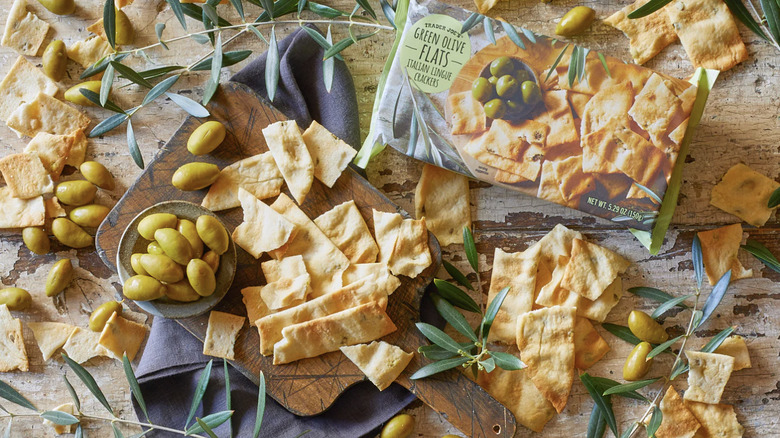 Trader Joe's Green Olive Flats Italian Lingue Crackers on a table next to package and olives