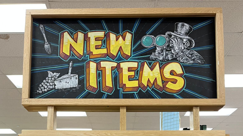 Sign reading 'new items' with chalk illustrations inside Trader Joe's store
