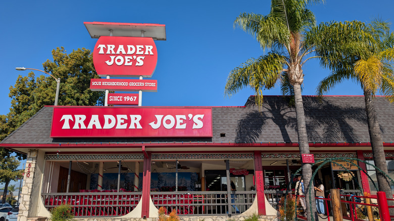 Front of a Trader Joe's store with signs and blue sky