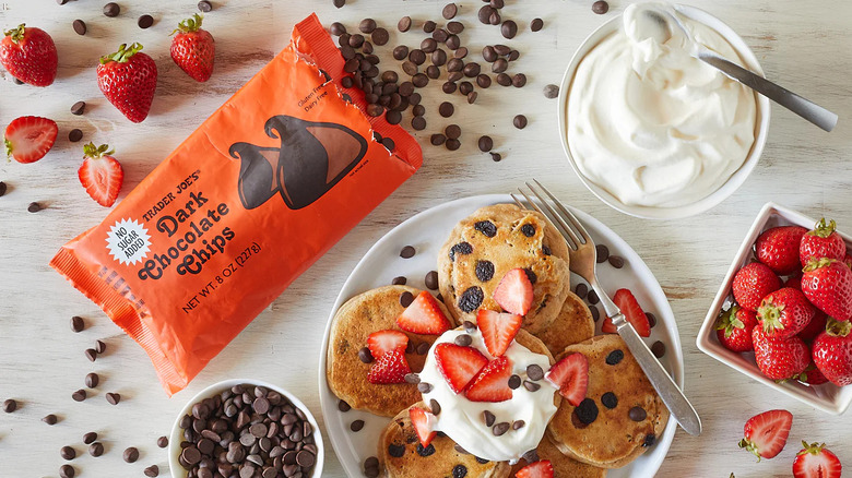 Trader Joe's Dark Chocolate Chips with a plate of pancakes, whipped cream, and strawberries
