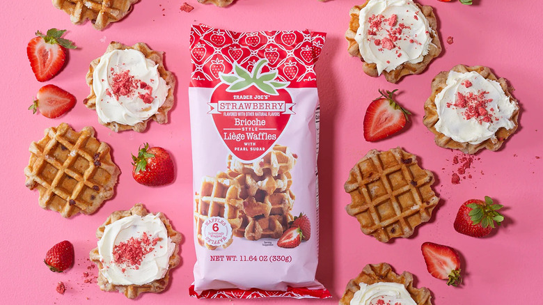 Trader Joe's Strawberry Brioche Style Liège Waffles stylized on a pink surface with strawberries and some topped with cream cheese