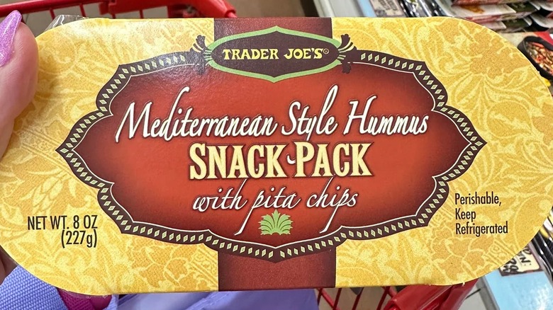 Close-up of hand holding Trader Joe's Mediterranean-Style Hummus Snack Pack