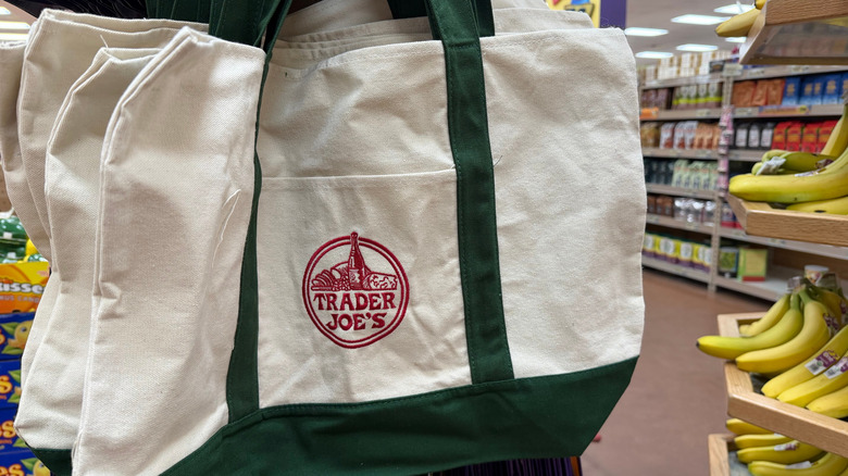 person carrying Trader Joe's tote in store