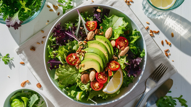 Salad with avocado, tomatoes, walnuts, and seeds