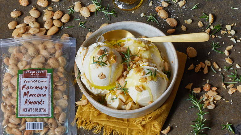 A bowl of vanilla ice cream topped with almonds and honey next to a bag of Trader Joe's roasted and salted rosemary Marcona almonds.