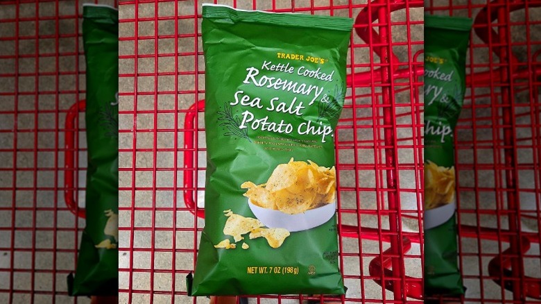 A bag of Trader Joe's Kettle Cooked Rosemary & Sea Salt Potato Chips in a red shopping cart
