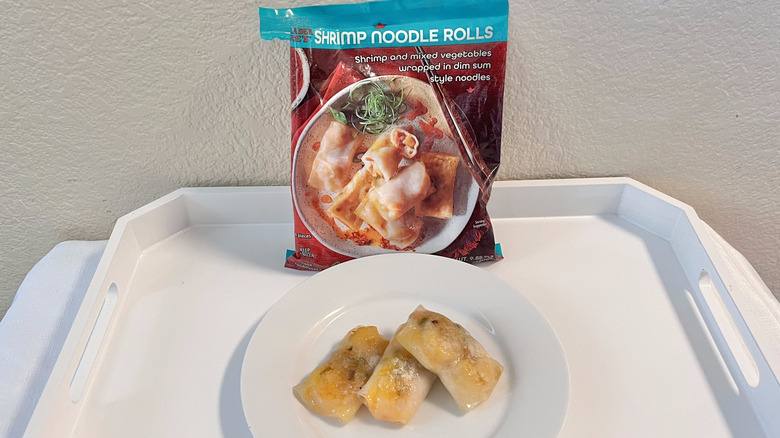 Trader Joe's Shrimp Noodle Rolls on a plate with the whole bag in the back leaning against the wall