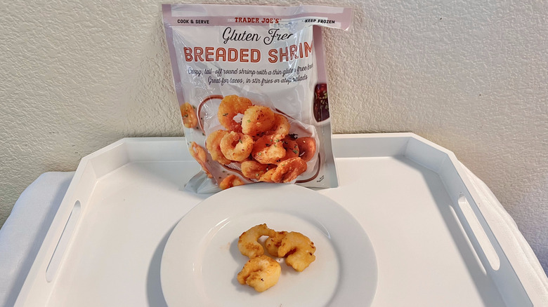 A bag of Trader Joe's Gluten Free Breaded Shrimp with four cooked shrimp on a plate