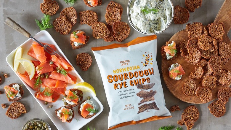 Bag of Trader Joe's Norwegian rye sourdough chips on table surrounded by chips, spread, and lox