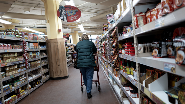 shopper with grocery cart in aisle at Trader Joe's