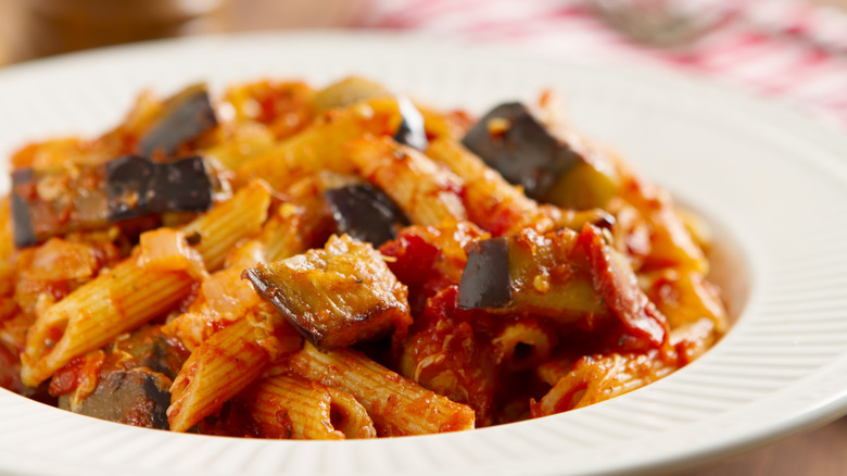 a plate of pasta alla norma, rigatoni with eggplant, tomato, and cheese