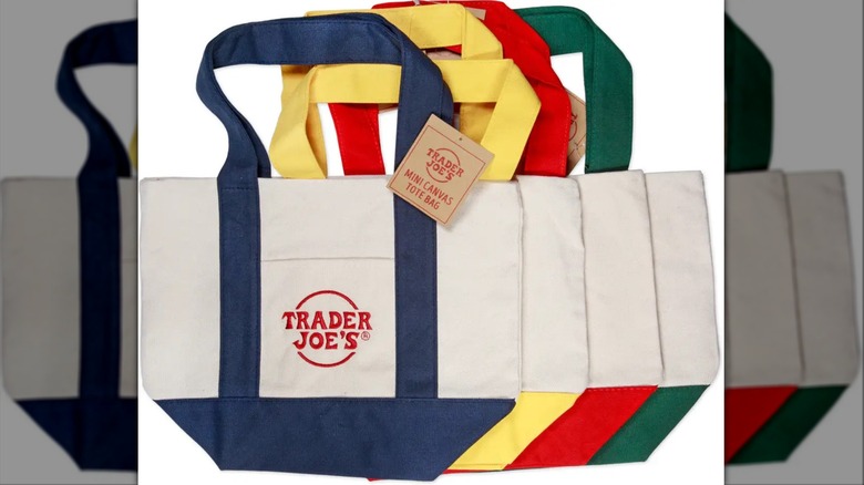 Trader Joe's mini canvas tote bags in red, blue, yellow, and green arranged in row