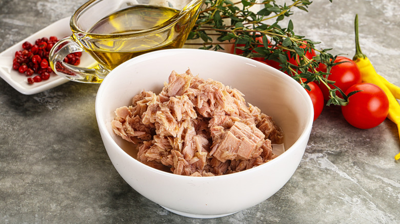 A bowl of canned tuna with other ingredients behind it