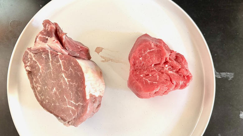Costco filet mignon and Trader Joe's filet mignon on white plate uncooked
