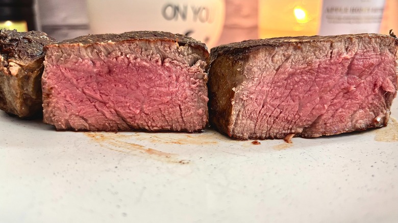Cut open Costco filet mignon cooked medium rare on white plate