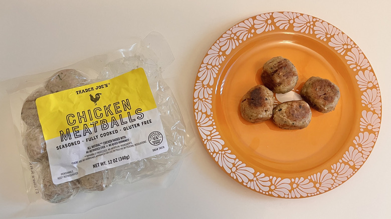 four Trader Joe's chicken meatballs on a plate beside the open package