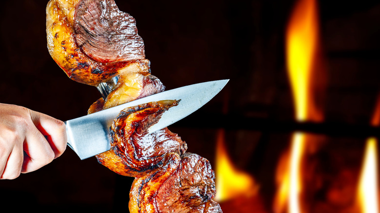 slicing meat at brazilian steakhouse