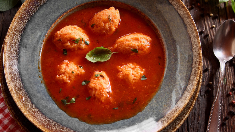 Tomato soup and dumplings with a basil leaf garnish