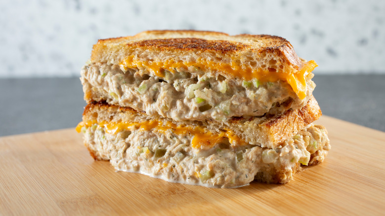 stacked tuna melt sandwich on wood board