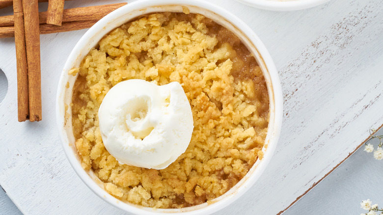 Top view of a fruit crumble with streusel and whipped cream topping.