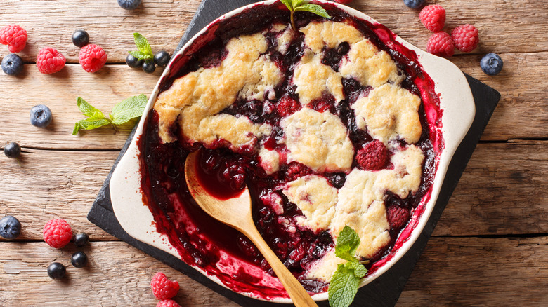 mixed berry cobbler with wooden spoon and mint