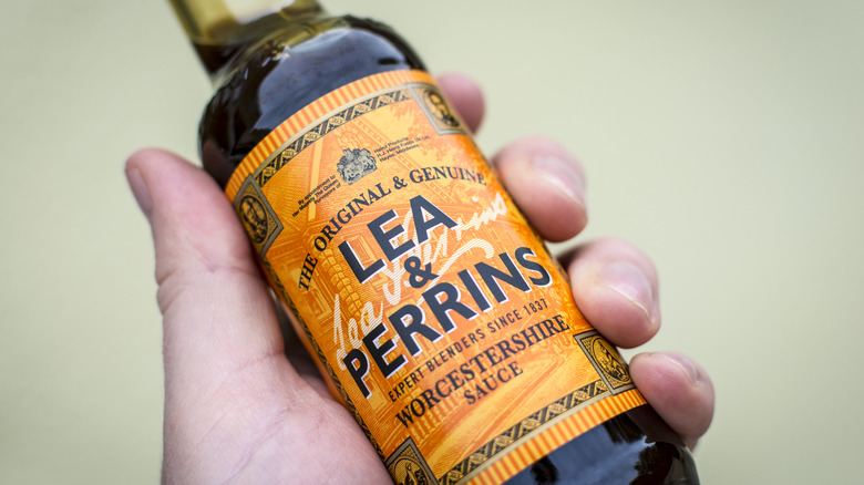 Someone holding a bottle of Lea and Perrins Worcestershire sauce