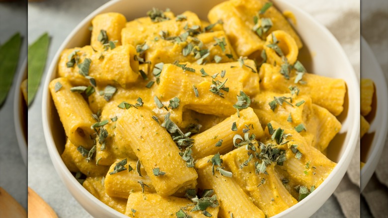 Butternut squash pasta sauce on rigatoni noodles in a white bowl