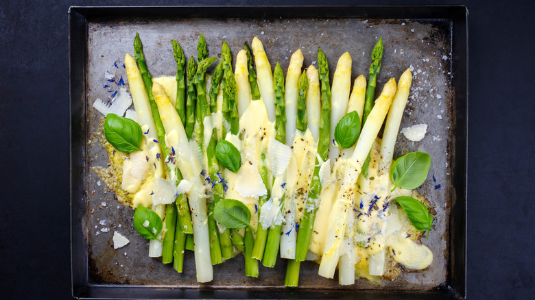 Asparagus and a sauce on a baking sheet