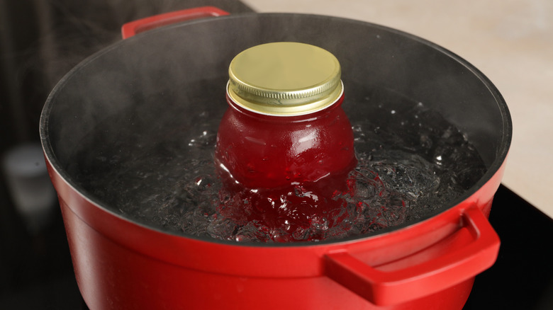 jar filled with something red in hot water bath