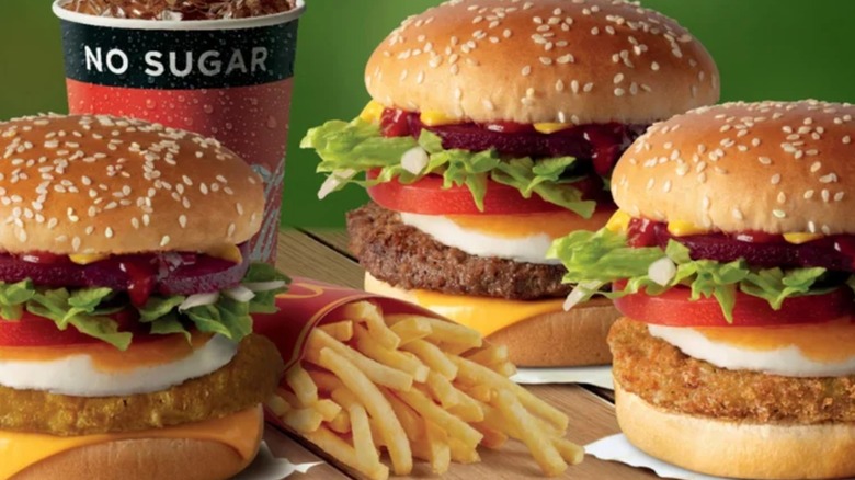 Three burgers with beets on top