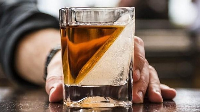 angled ice cube in whiskey glass
