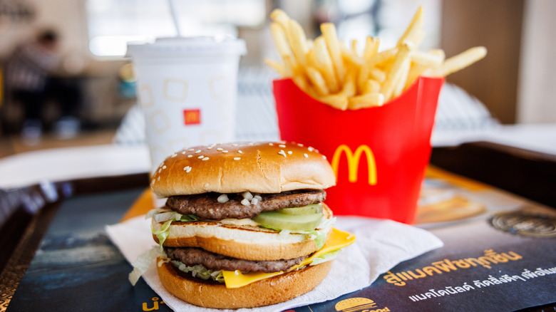 Close up on a McDonald's Big Mac with a container of fries and a drink in the background