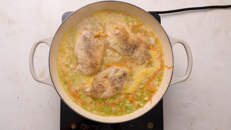 chicken and broth in a skillet