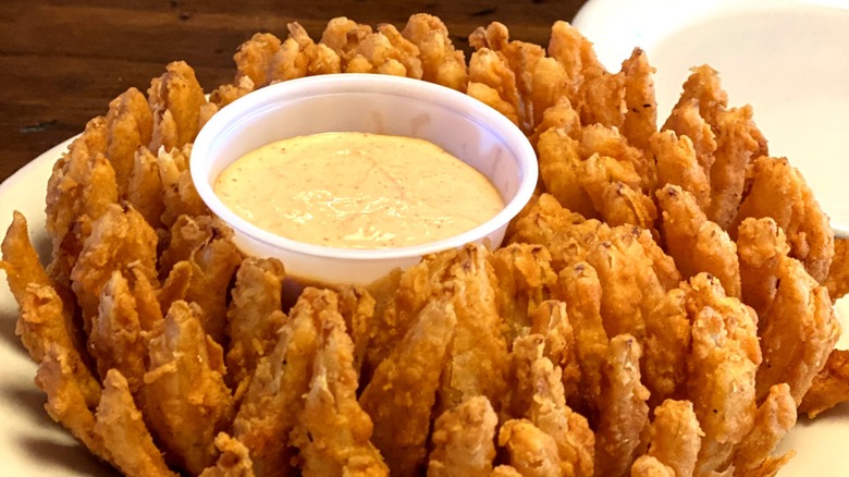 Bloomin' Onion or Cactus Blossom fried onion dish served with cup of sauce in the middle
