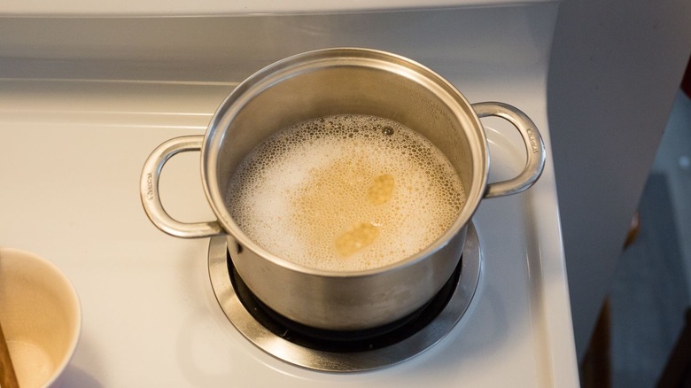 Pot with couscous and bubbly water on stovetop