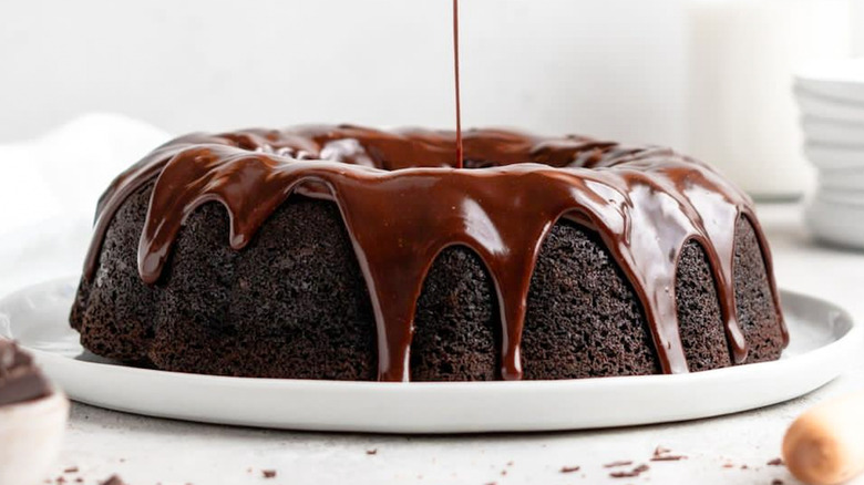 Chocolate bundt cake being drizzled with chocolate glaze