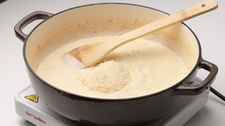 adding Parmesan to sauce