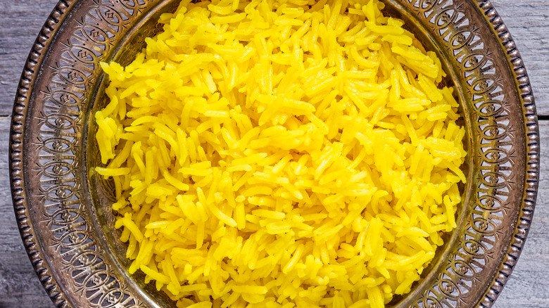 turmeric rice in sliver bowl
